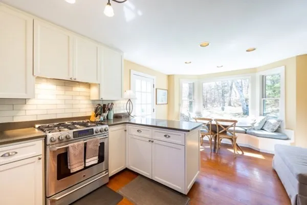 a kitchen with a stove a sink a dining table and chairs