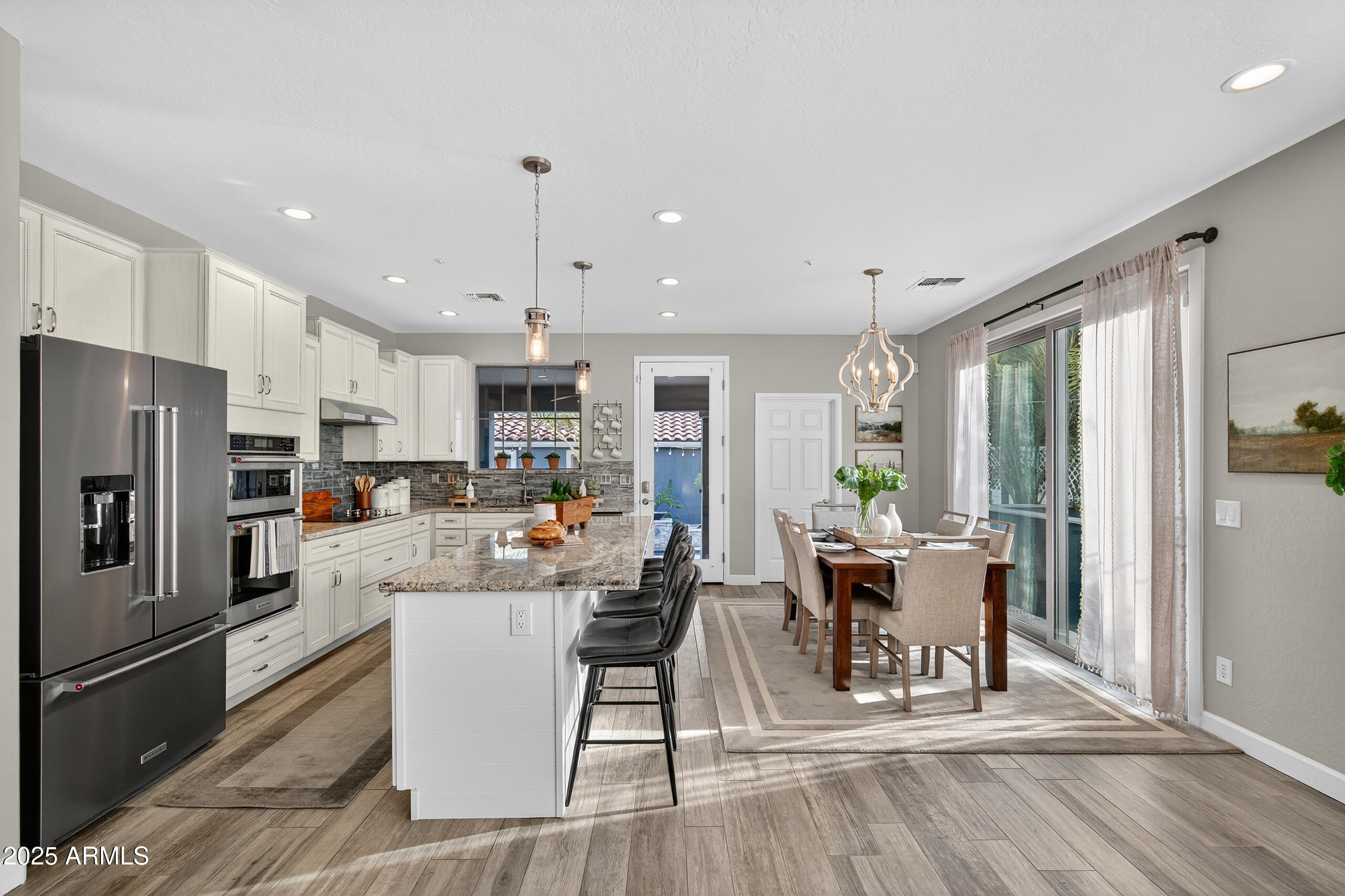 3021 East Agritopia Loop North Gilbert, AZ 85296 - Photo 15 of 68 a view of a dining room with furniture a kitchen and chandelier