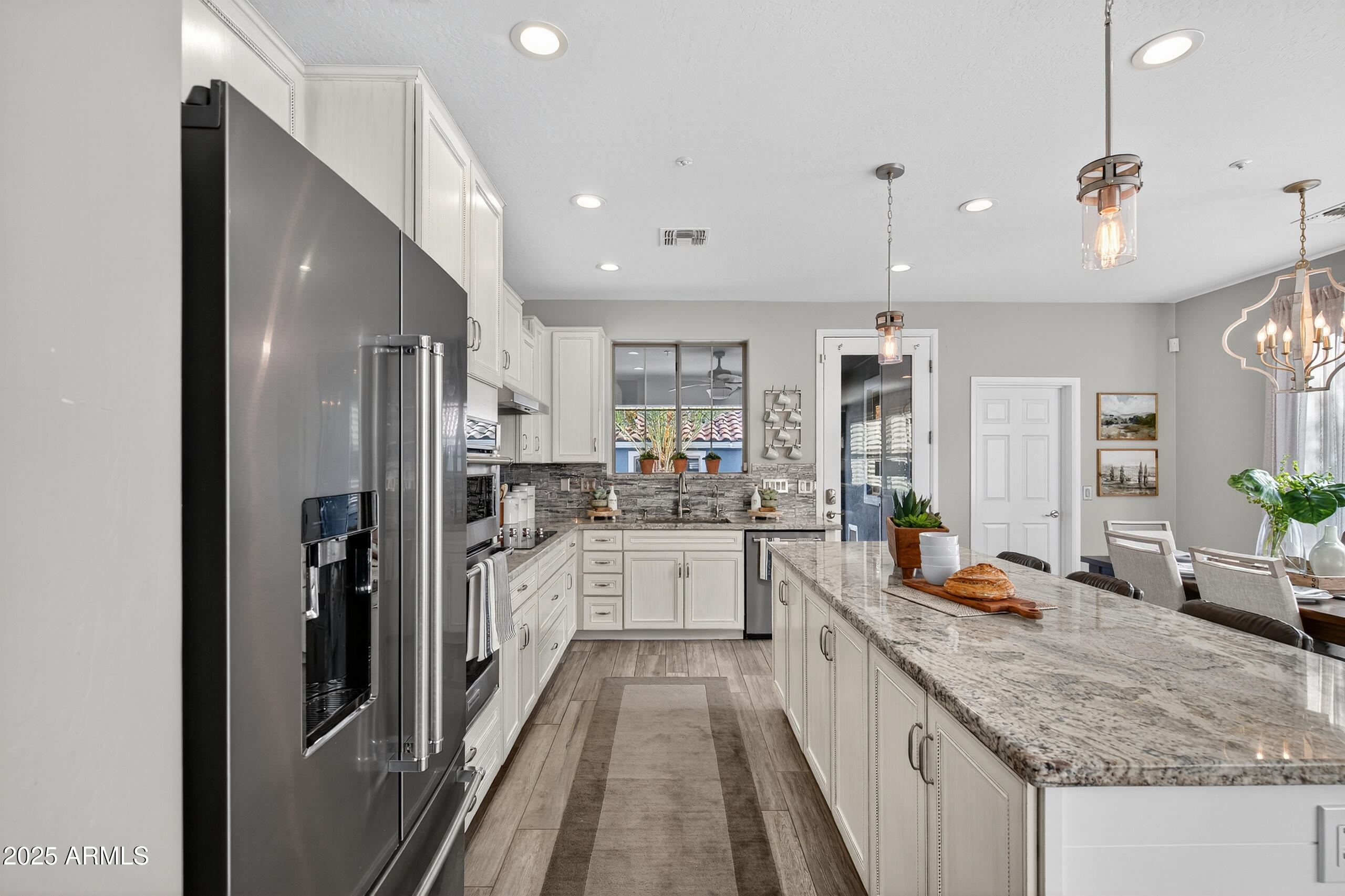 3021 East Agritopia Loop North Gilbert, AZ 85296 - Photo 17 of 68 a large kitchen with stainless steel appliances kitchen island granite countertop a large counter top and stainless steel appliances