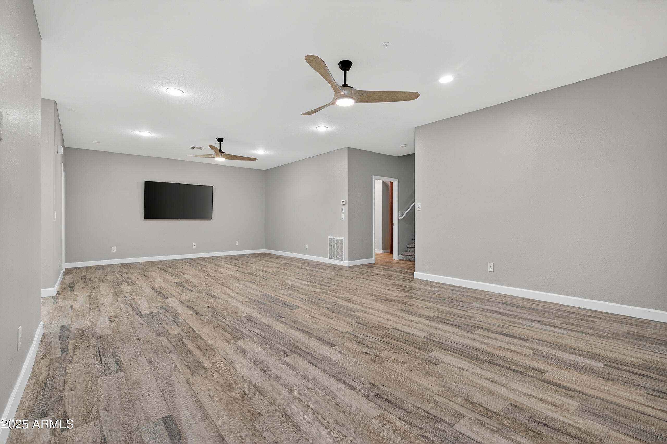 3021 East Agritopia Loop North Gilbert, AZ 85296 - Photo 28 of 68 a view of an empty room with wooden floor and a ceiling fan