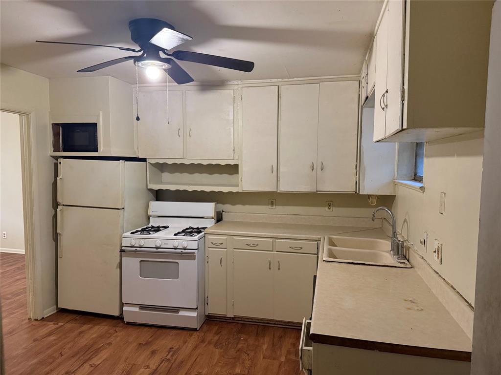 1007 Westway Street Denton, TX 76201 - Photo 4 of 15 a kitchen with a stove a sink and a refrigerator