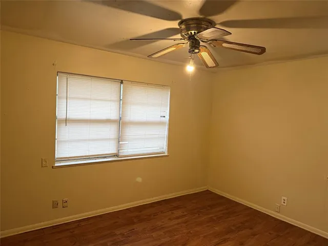 an empty room with a window and wooden floor