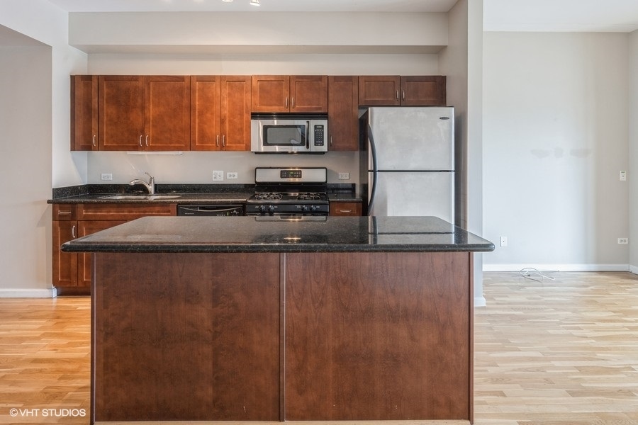 4848 North Sheridan Road, Unit 208 Chicago, IL 60640 - Photo 3 of 15 a kitchen with stainless steel appliances granite countertop a refrigerator and a stove top oven