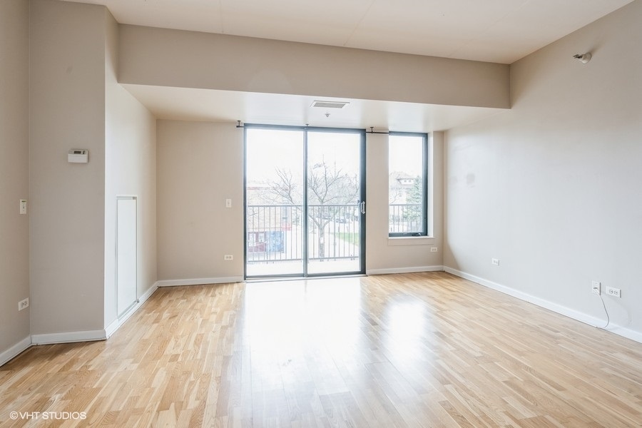 4848 North Sheridan Road, Unit 208 Chicago, IL 60640 - Photo 6 of 15 a view of an empty room with wooden floor and a window