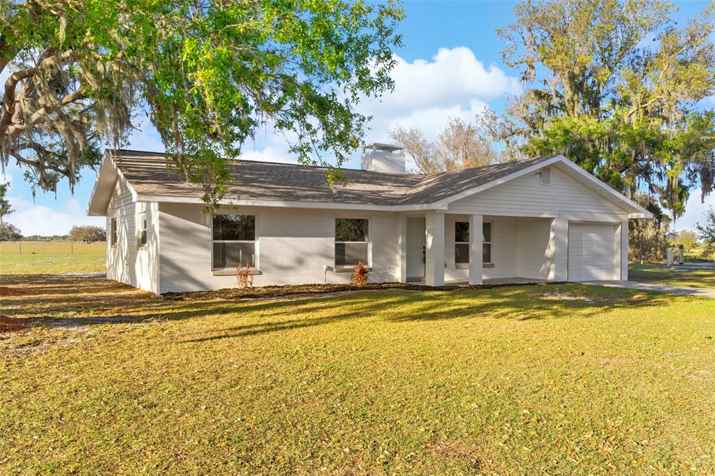 a view of a house with swimming pool and a yard