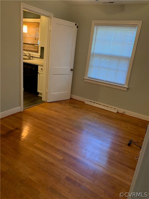 5254 Tilford Road Richmond, VA 23225 - Photo 9 of 13 an empty room with wooden floor cabinet and windows