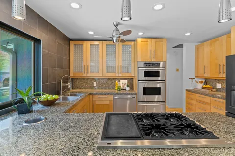 a kitchen with stainless steel appliances granite countertop a sink stove and refrigerator