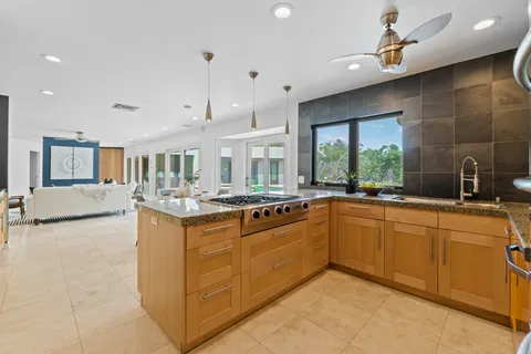 a large kitchen with kitchen island a large counter space a sink appliances and cabinets