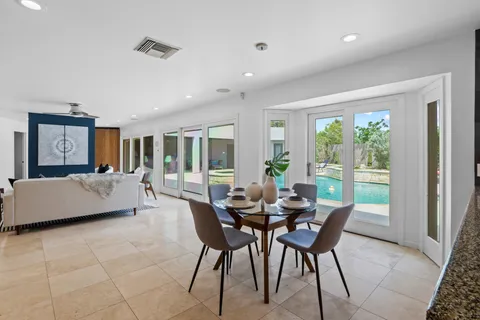 a dining room with furniture and a large window