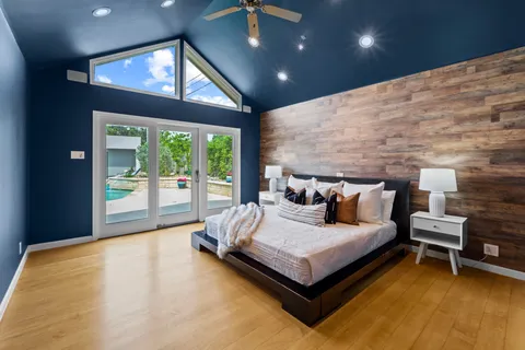 a spacious bedroom with a bed and a large window
