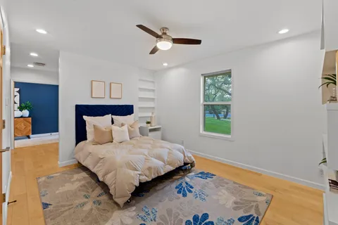 a bedroom with a bed and a ceiling fan
