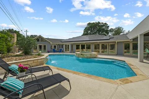 a view of house with swimming pool outdoor seating