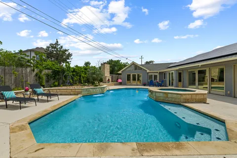 a house view with swimming pool and sitting space
