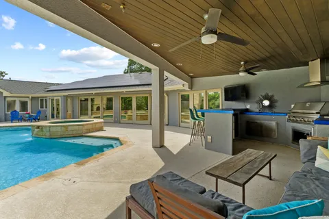 a view of a house with swimming pool and sitting area