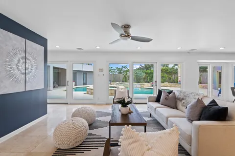 a living room with furniture ceiling fan and a large window