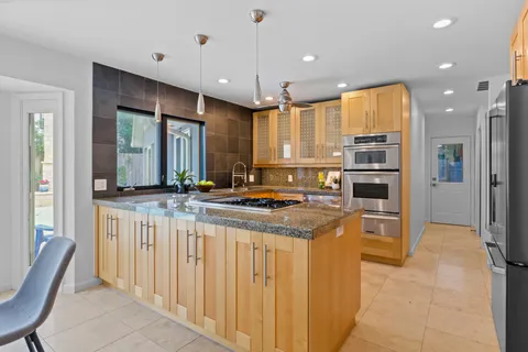 a kitchen with stainless steel appliances granite countertop a stove and a refrigerator