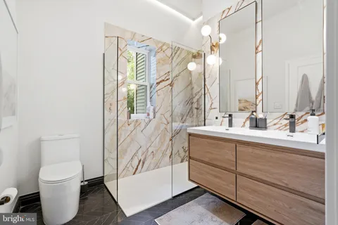 a bathroom with a sink a toilet and shower
