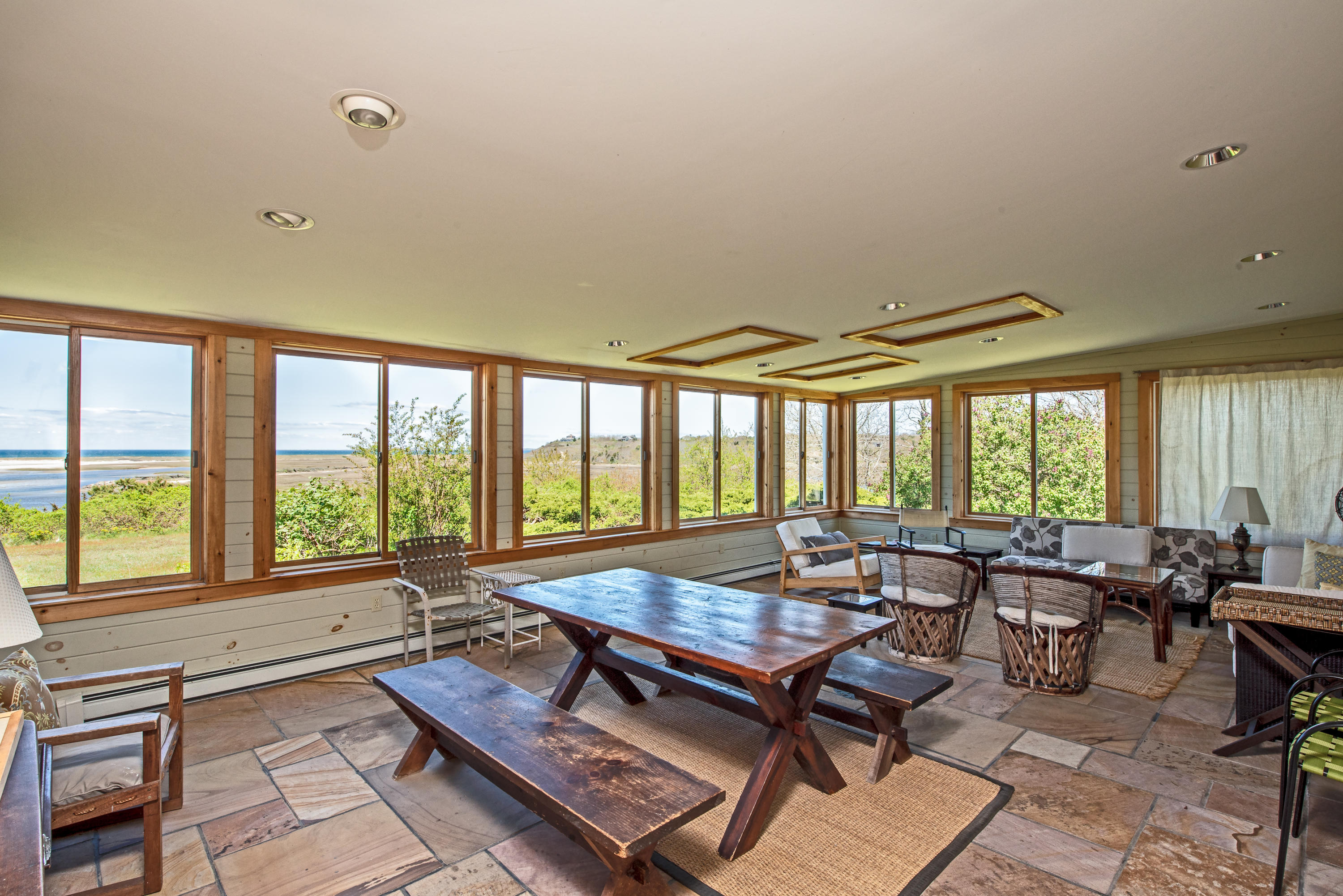 63 Depot Road Truro, MA 02666 - Photo 14 of 36 a living room with furniture a table and large windows