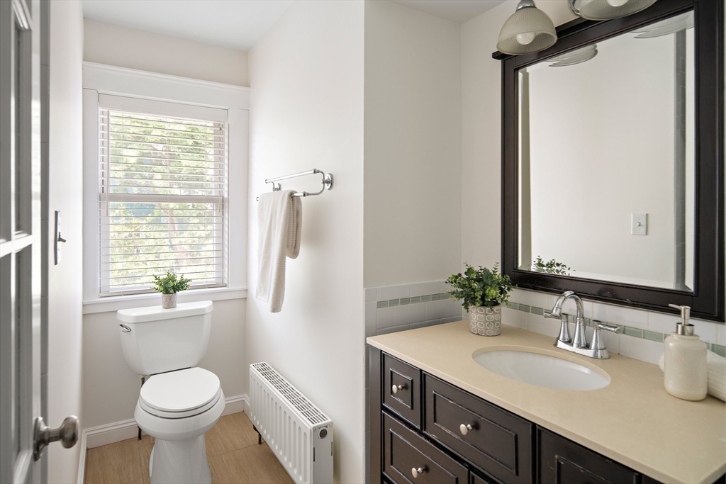 60 Rosemary Street Needham, MA 02494 - Photo 23 of 29 a bathroom with a granite countertop toilet sink and a mirror