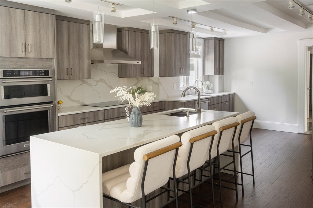 60 Rosemary Street Needham, MA 02494 - Photo 3 of 29 a kitchen with kitchen island a stove a table and chairs in it