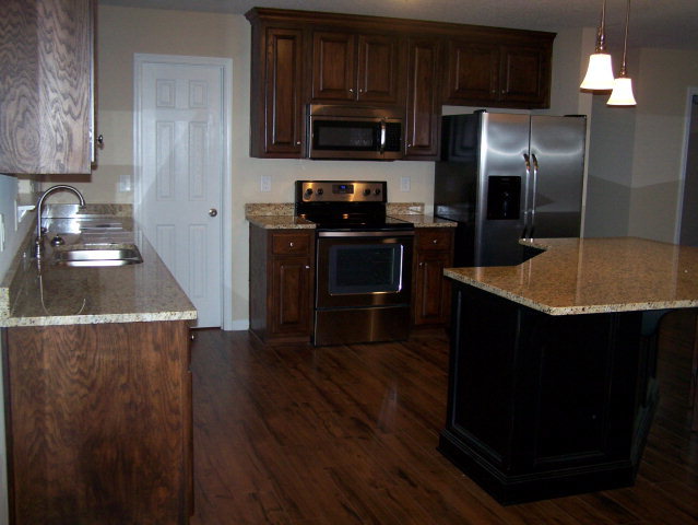 232 Sanders Road, Unit 6 Macon, GA 31210 - Photo 5 of 16 a kitchen with granite countertop stainless steel appliances a stove a refrigerator a sink and a oven with wooden floor