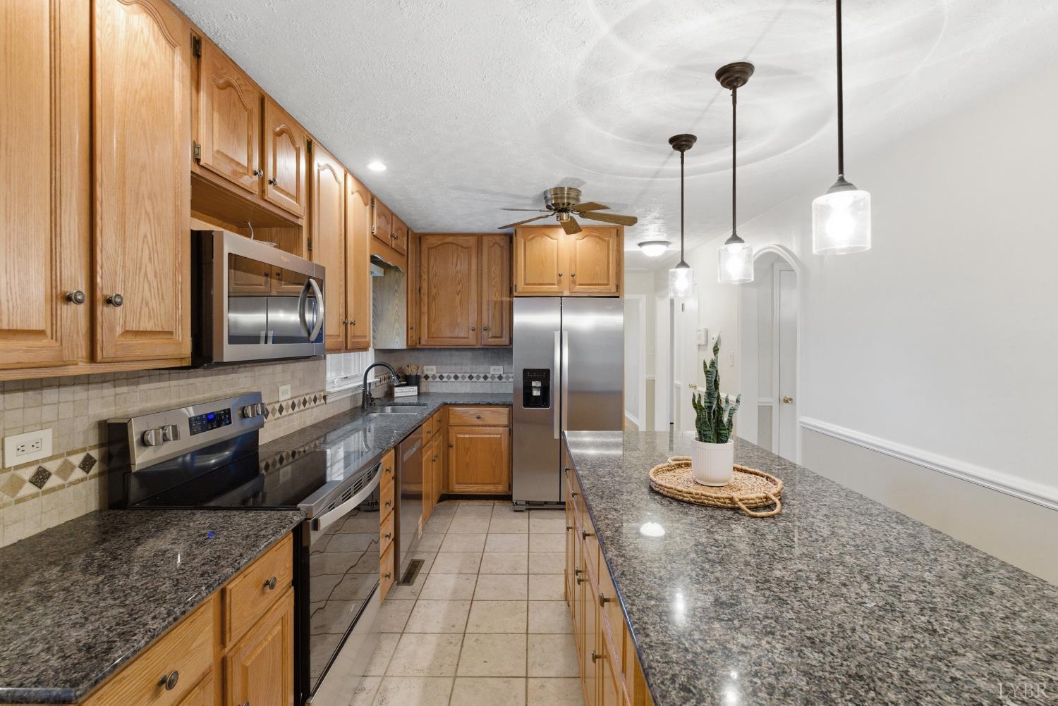 7092 Stage Coach Road Nathalie, VA 24577 - Photo 17 of 57 a kitchen with stainless steel appliances granite countertop a sink a stove and a wooden floors