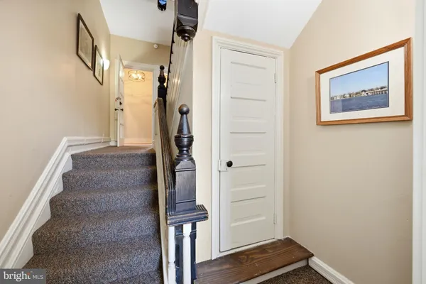 a view of hallway with stairs and wooden floor