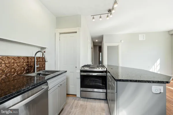 a kitchen with stainless steel appliances granite countertop a stove and a refrigerator
