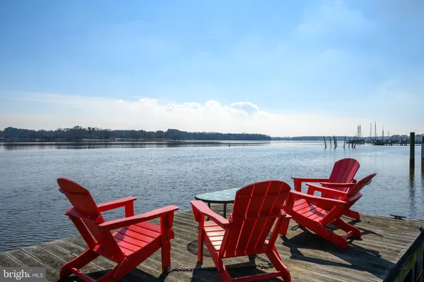 a view of a lake with table and chairs