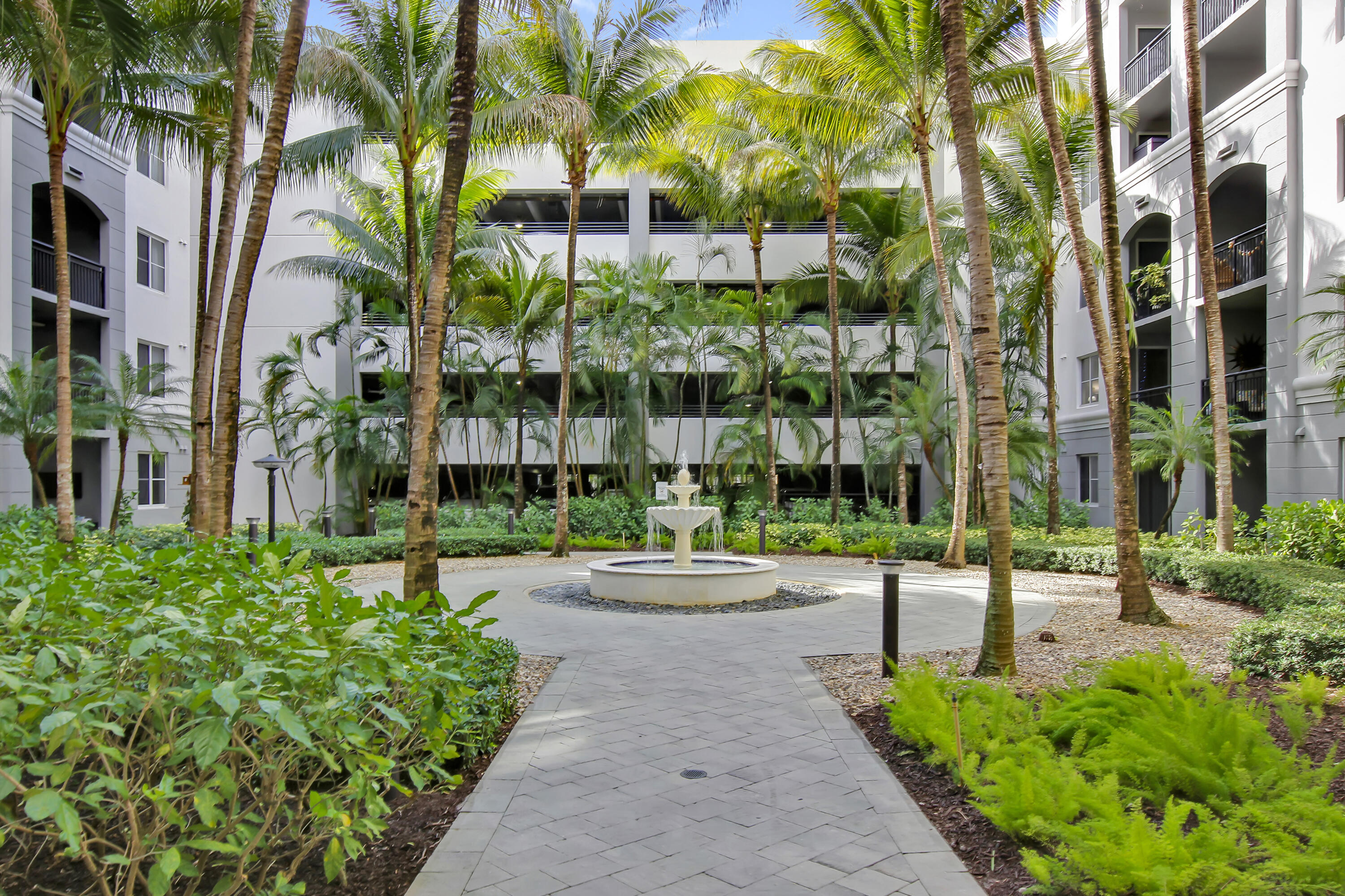 a view of a garden with tall buildings