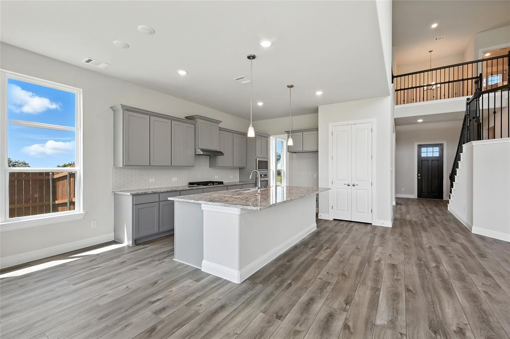 560 Flint Road Waxahachie, TX 75167 - Photo 3 of 40 a large kitchen with stainless steel appliances granite countertop a large counter top and wooden floors