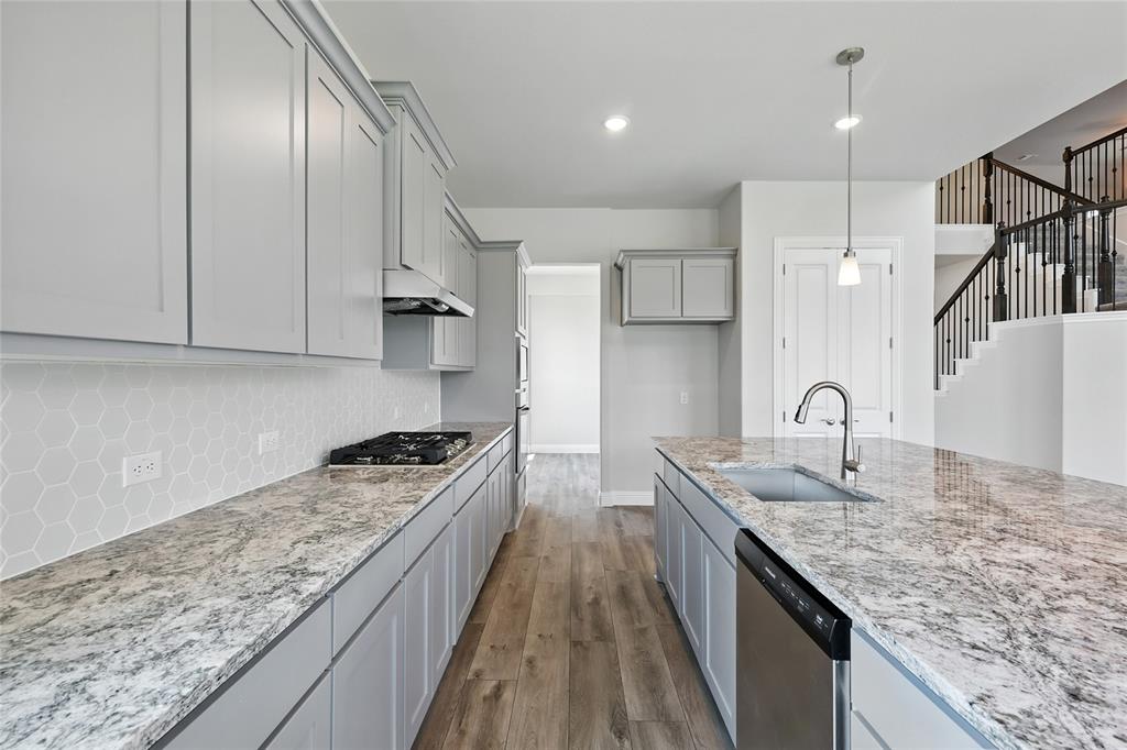 560 Flint Road Waxahachie, TX 75167 - Photo 4 of 40 a kitchen with granite countertop stainless steel appliances sink stove and cabinets