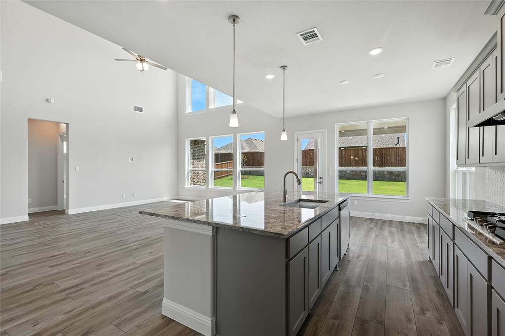 560 Flint Road Waxahachie, TX 75167 - Photo 40 of 40 a dining hall with stainless steel appliances granite countertop a kitchen island a stove and a wooden floors