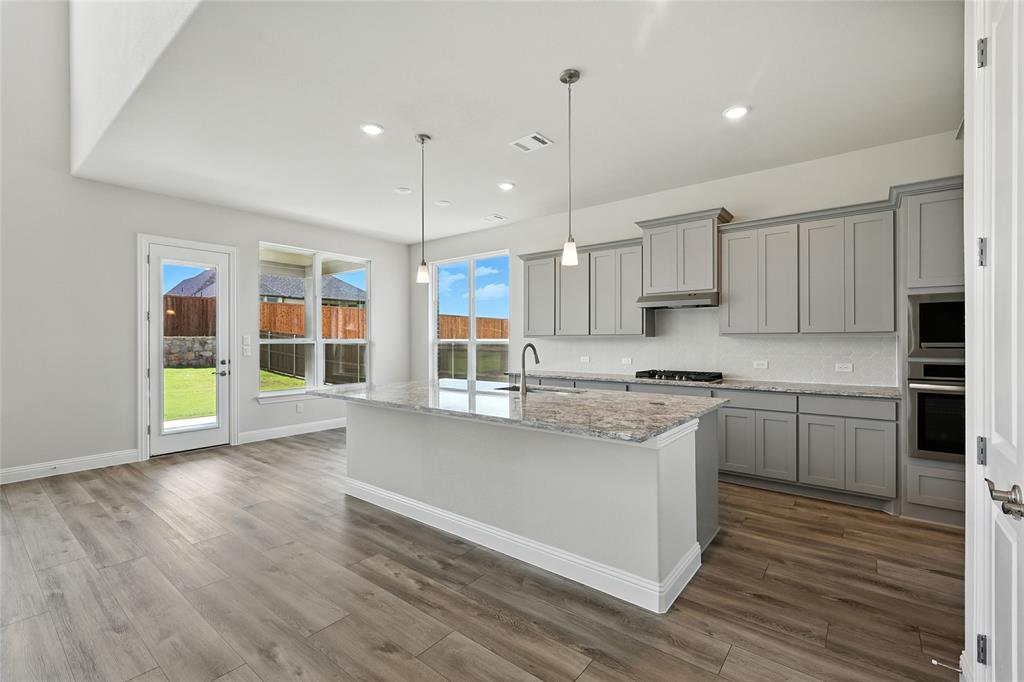 560 Flint Road Waxahachie, TX 75167 - Photo 6 of 40 a kitchen with granite countertop a stove a sink and a refrigerator