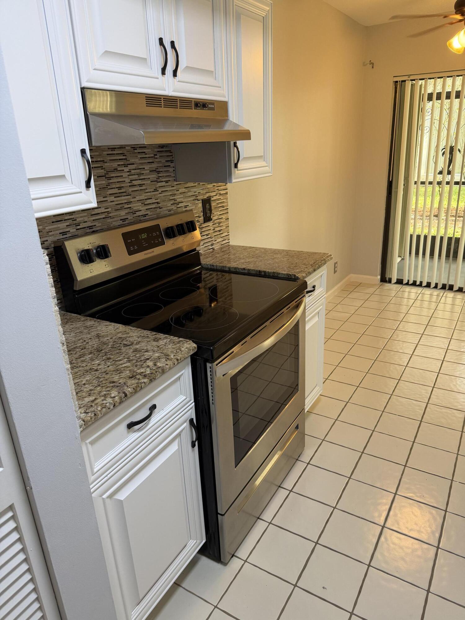 12628 Shoreline Drive, Unit 9C Wellington, FL 33414 - Photo 11 of 32 a stove top oven sitting inside of a kitchen