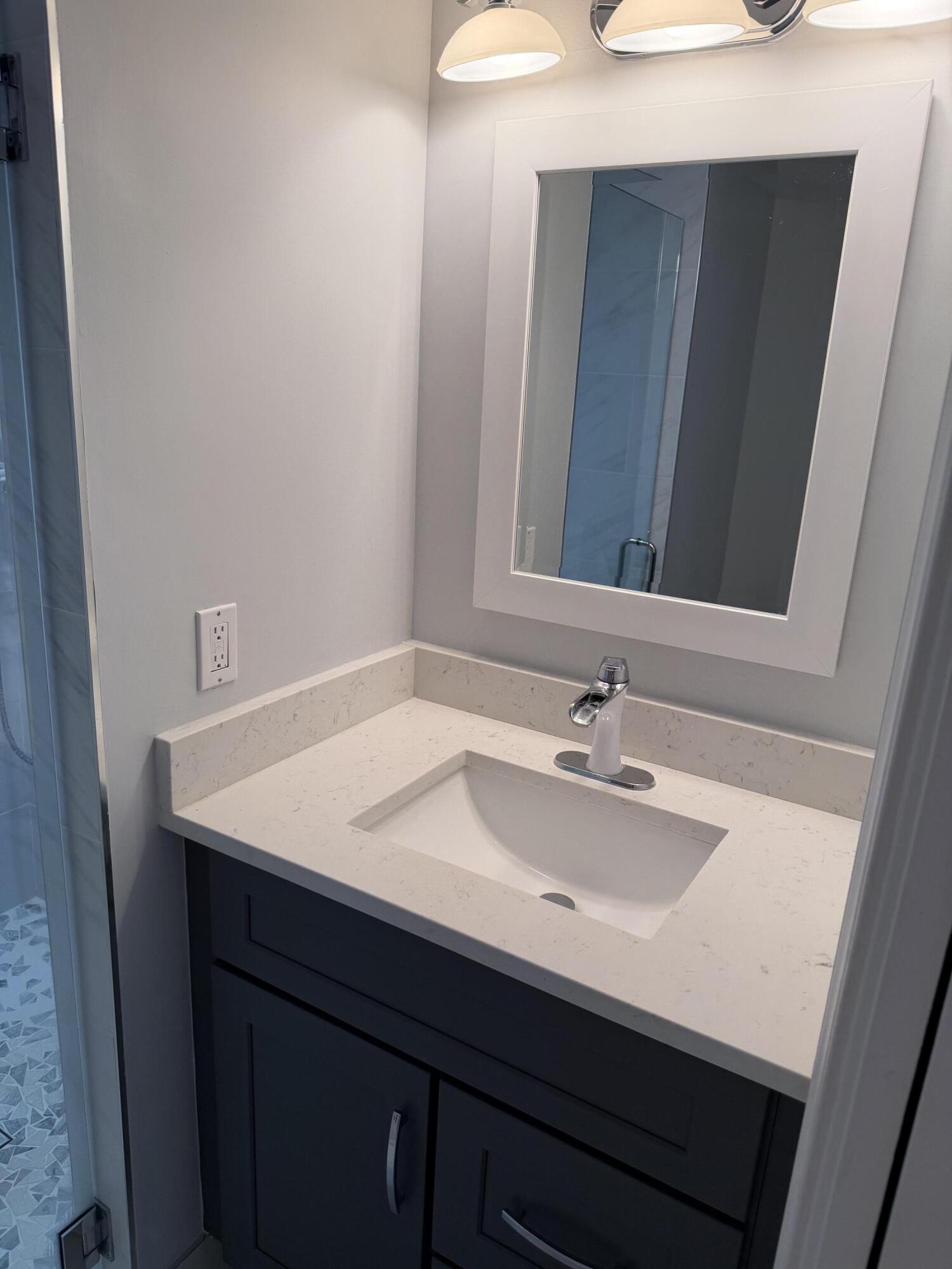 12628 Shoreline Drive, Unit 9C Wellington, FL 33414 - Photo 23 of 32 a bathroom with a sink and a mirror