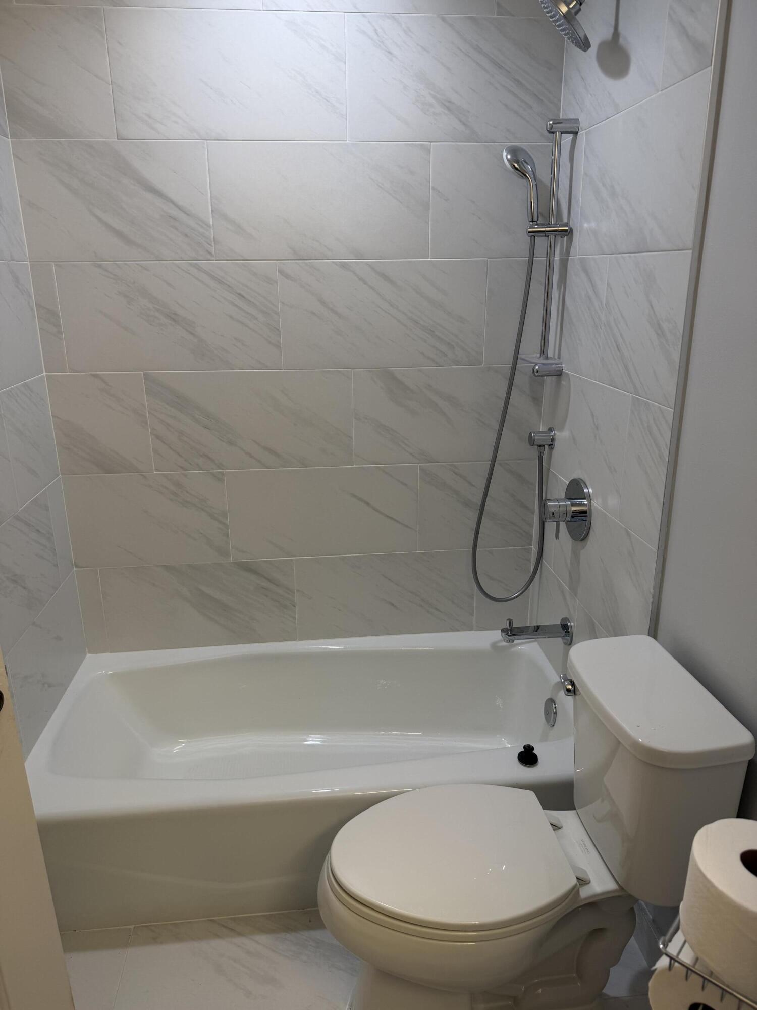 12628 Shoreline Drive, Unit 9C Wellington, FL 33414 - Photo 25 of 32 a white toilet sitting next to a bath tub shower