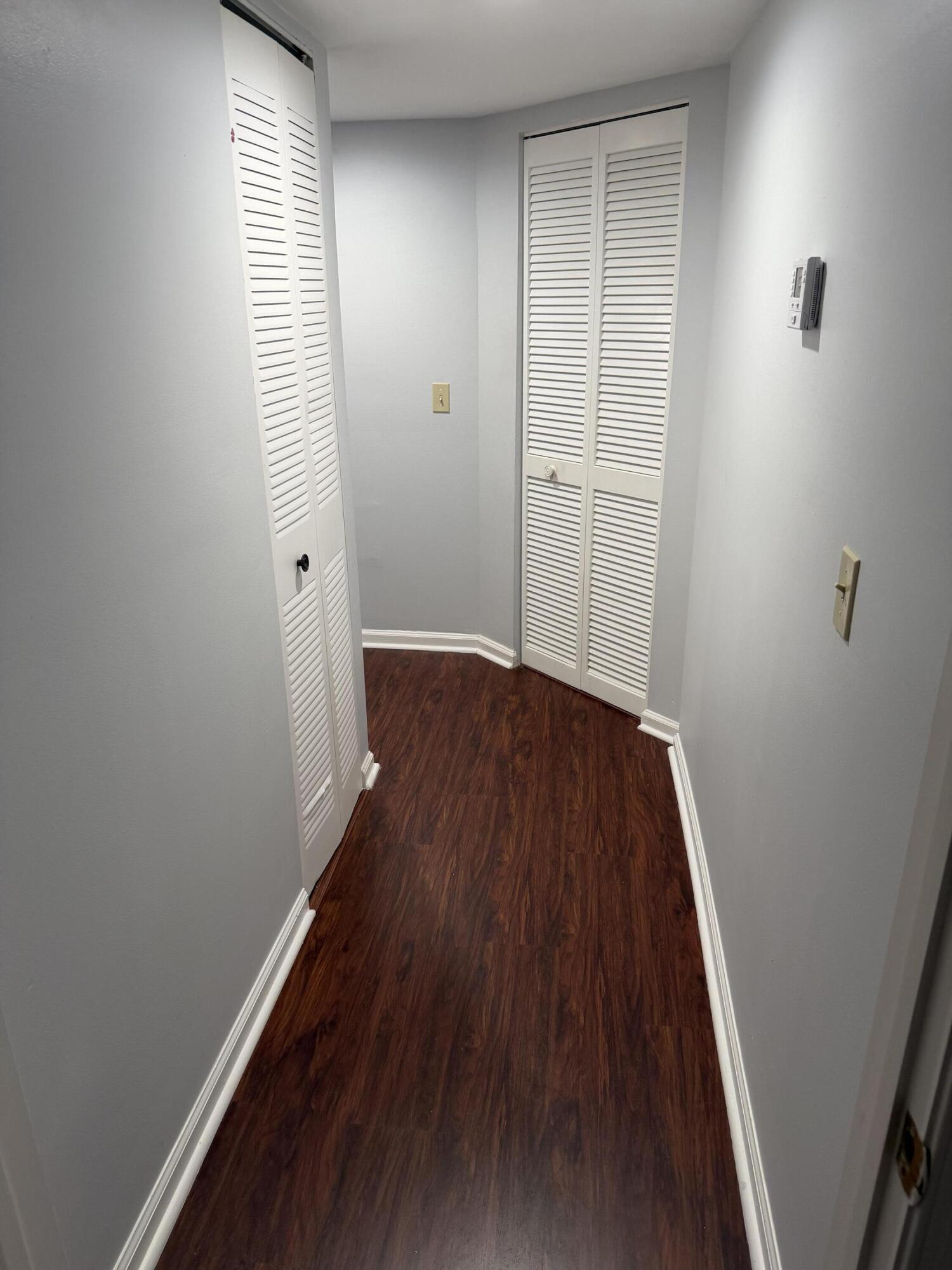 12628 Shoreline Drive, Unit 9C Wellington, FL 33414 - Photo 26 of 32 an empty room with wooden floor and windows