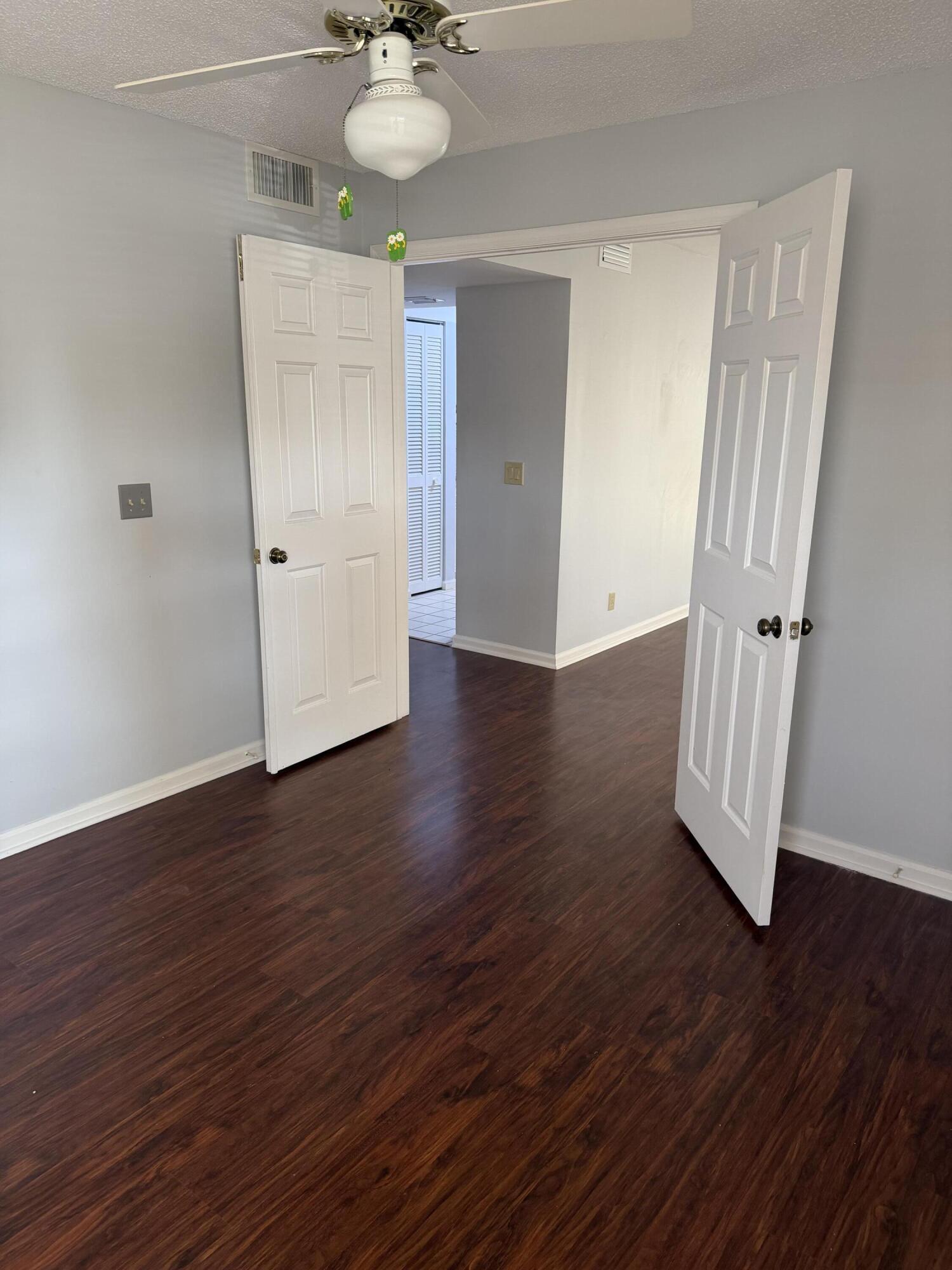 12628 Shoreline Drive, Unit 9C Wellington, FL 33414 - Photo 28 of 32 an empty room with wooden floor and staircase