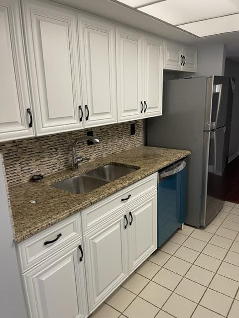 12628 Shoreline Drive, Unit 9C Wellington, FL 33414 - Photo 6 of 32 a kitchen with granite countertop white cabinets and stainless steel appliances