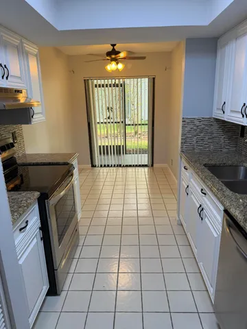 a kitchen with granite countertop a stove top oven cabinets and a stove top oven