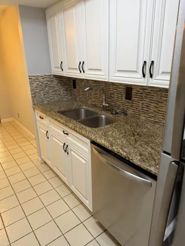 a kitchen with granite countertop white cabinets and sink