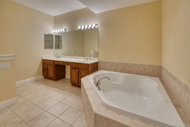 a spacious bathroom with a bathtub sink and mirror
