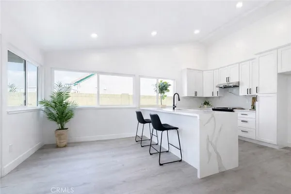 a kitchen with white cabinets and window