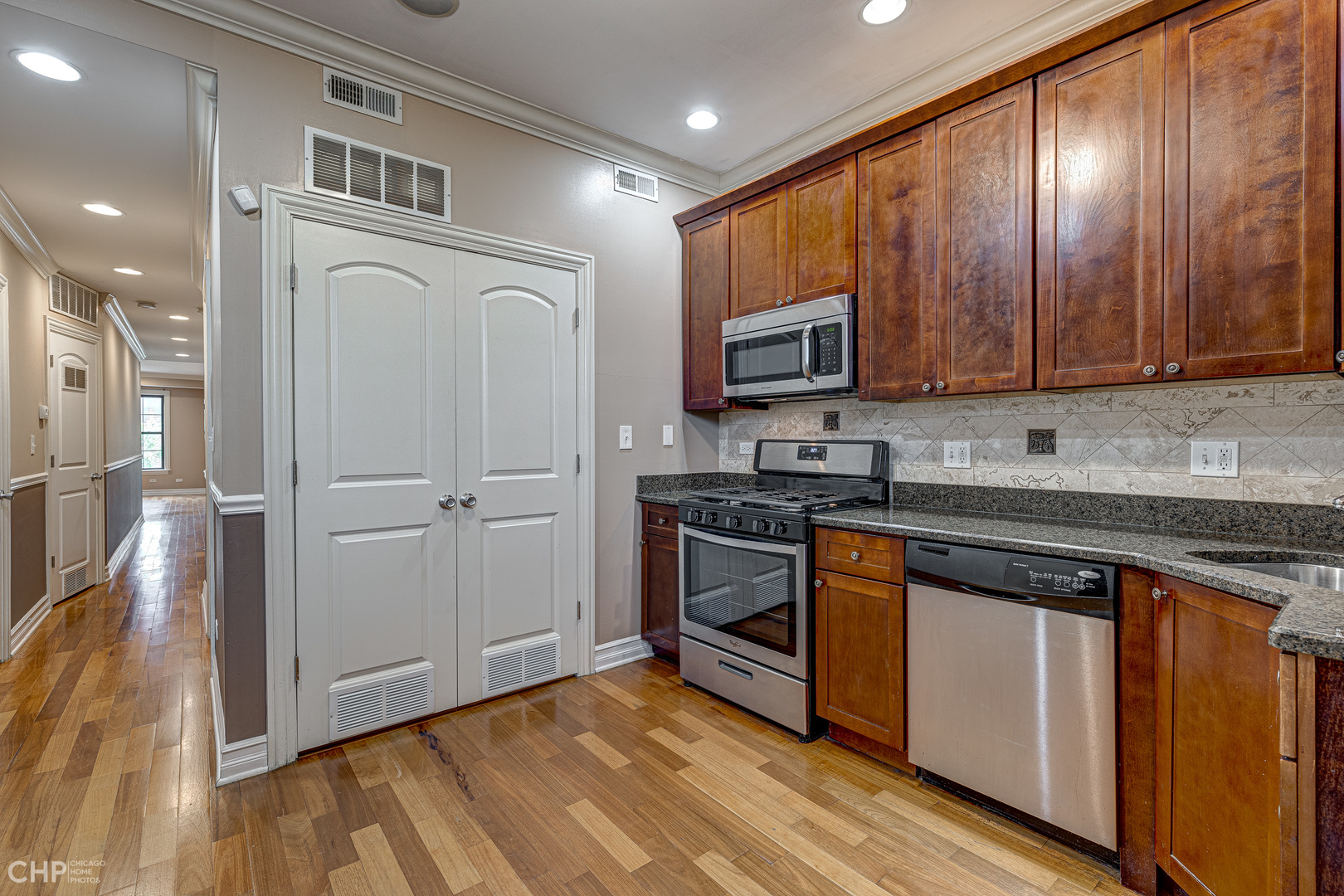 1363 East 64th Street, Unit 2 Chicago, IL 60637 - Photo 10 of 12 a kitchen with granite countertop wooden cabinets and stainless steel appliances