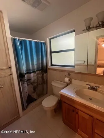 a bathroom with a sink a toilet a mirror and shower
