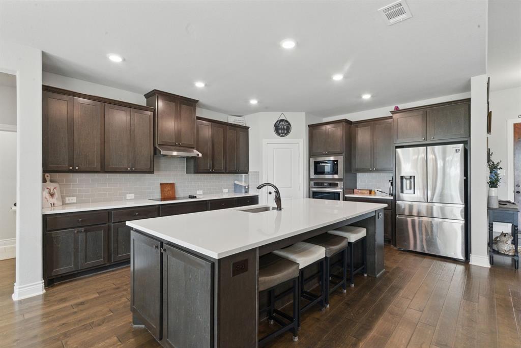 3385 Dps Tower Road Perrin, TX 76486 - Photo 14 of 35 a large kitchen with stainless steel appliances a sink and a refrigerator