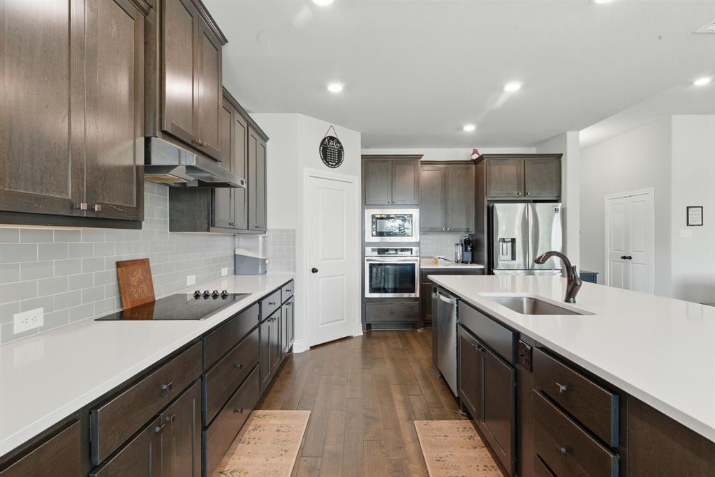 3385 Dps Tower Road Perrin, TX 76486 - Photo 15 of 35 a kitchen with kitchen island granite countertop a sink stainless steel appliances and cabinets