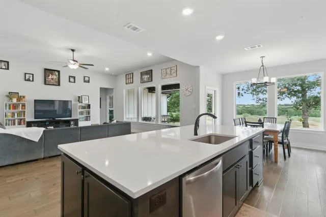 a kitchen with granite countertop a table chairs stove and kitchen view