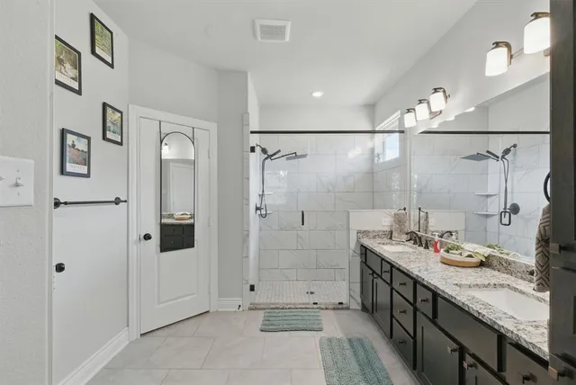 a bathroom with a granite countertop shower sink and mirror